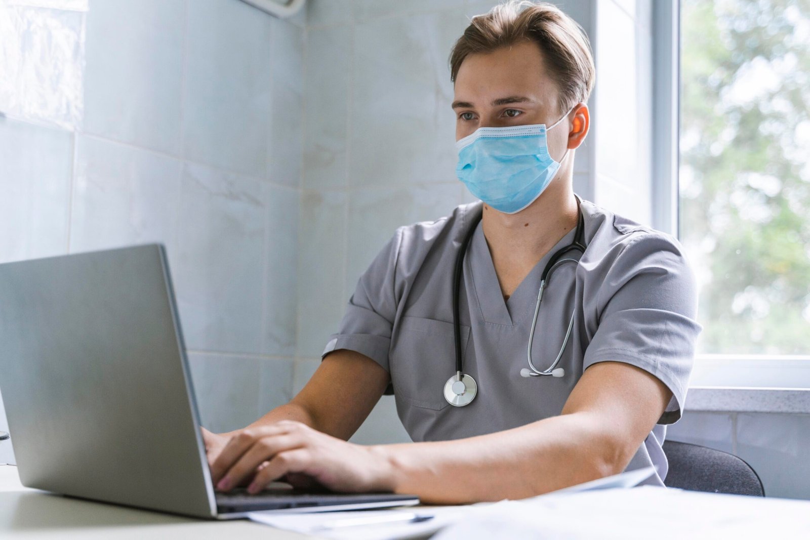 Doctor With Stethoscope Medical Mask Working Laptop Scaled